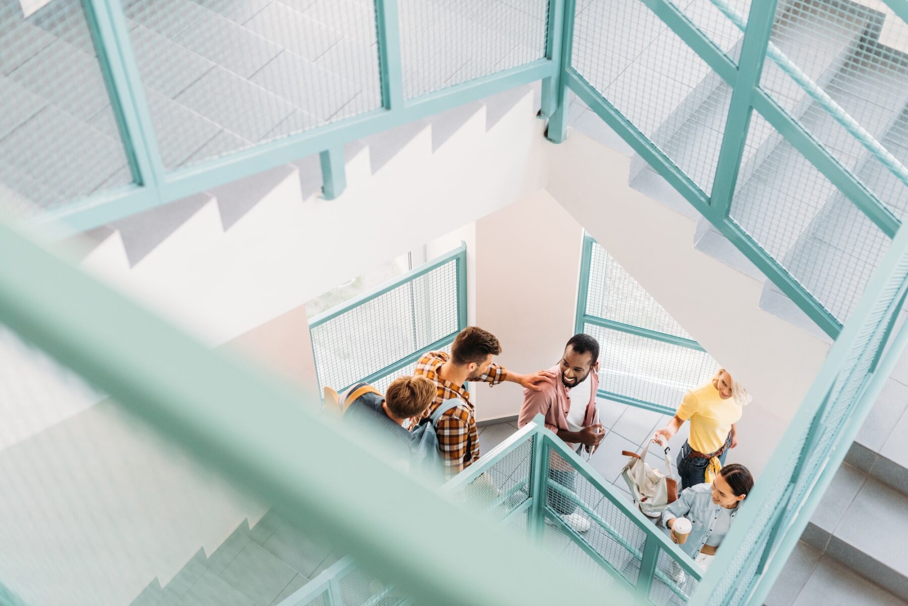 high angle view of young students walking down stairs at college